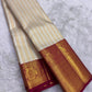 Handwoven Kanchi Pattu Butta saree in ivory with ornate all-over gold zari body and deep crimson Mayil Butta peacock pallu, full folded view