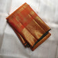 Close-up of shot amber golden orange silk body with Zari Kattam gold grid and green selvedge — Kanchipuram Veldhari