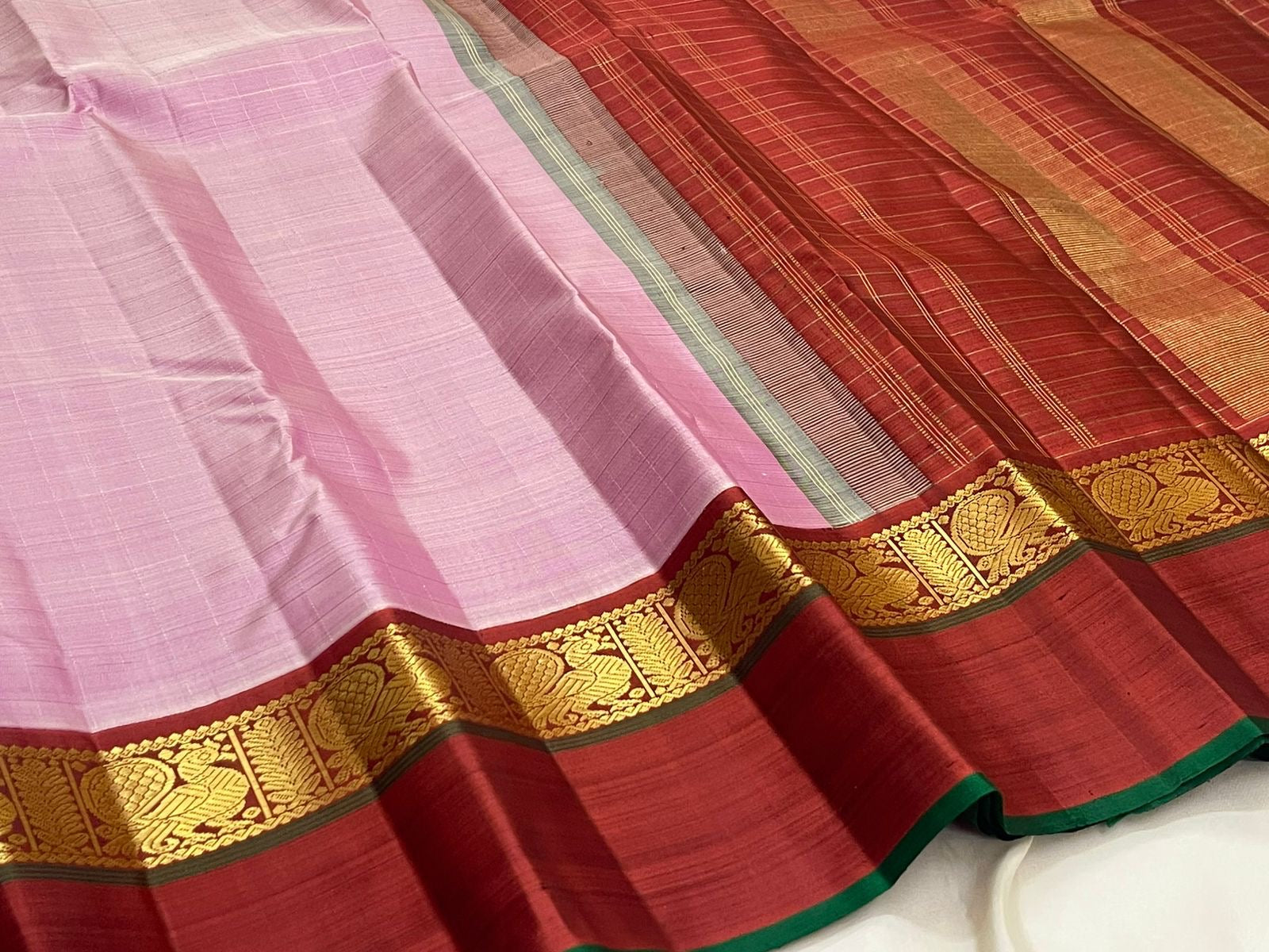 Mauve pink and deep maroon Kanjivaram Korvai saree folded — Kaal Irangiya border visible