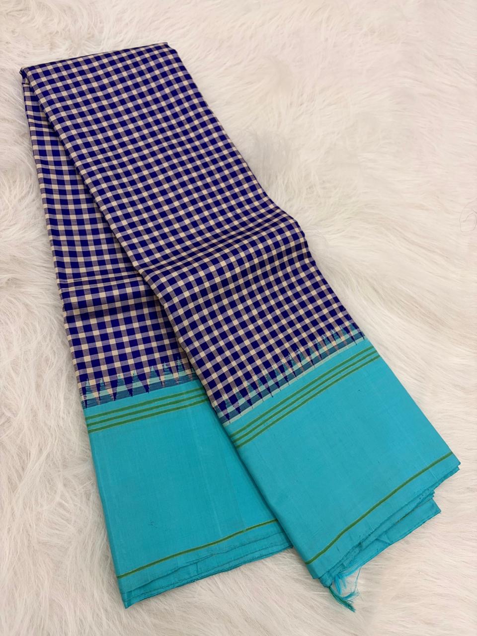 Folded view of navy blue and white handwoven pure silk Kanchi Pattu saree with Kanchi Kattam check body and sky blue border