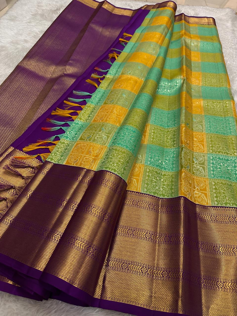 Handwoven KanchiPattu Bomkai Butta saree in turquoise and saffron figural panels with deep purple gold zari border, full folded view