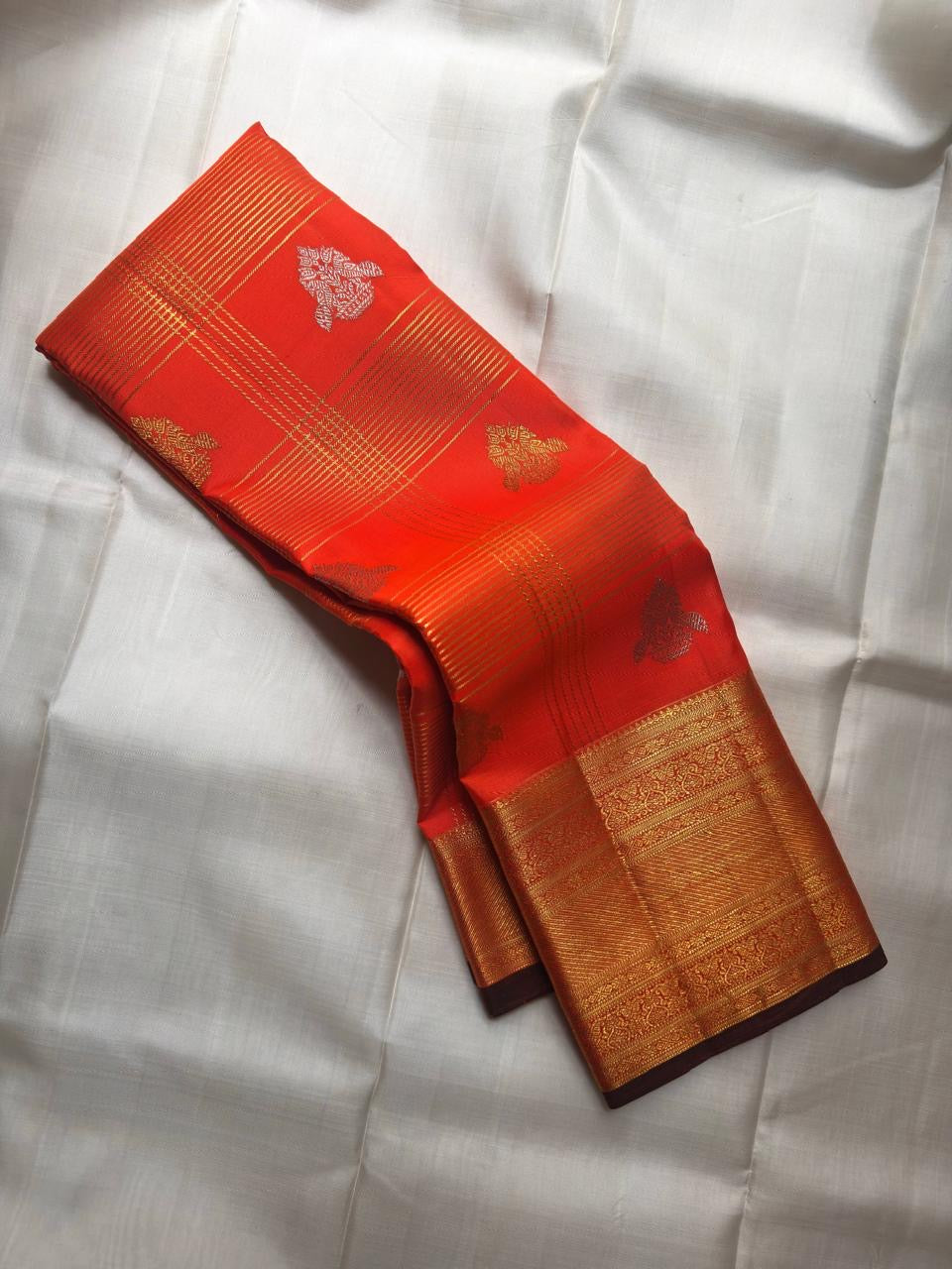 Close-up of shot burnt orange silk body with Zari Kattam gold grid and Yaanai Butta in antique gold zari — Kanchi Pattu Veldhari
