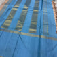 Cerulean blue Korvai border detail with Thazhampoo Reku gold zari lines on handwoven taupe KanchiPattu saree