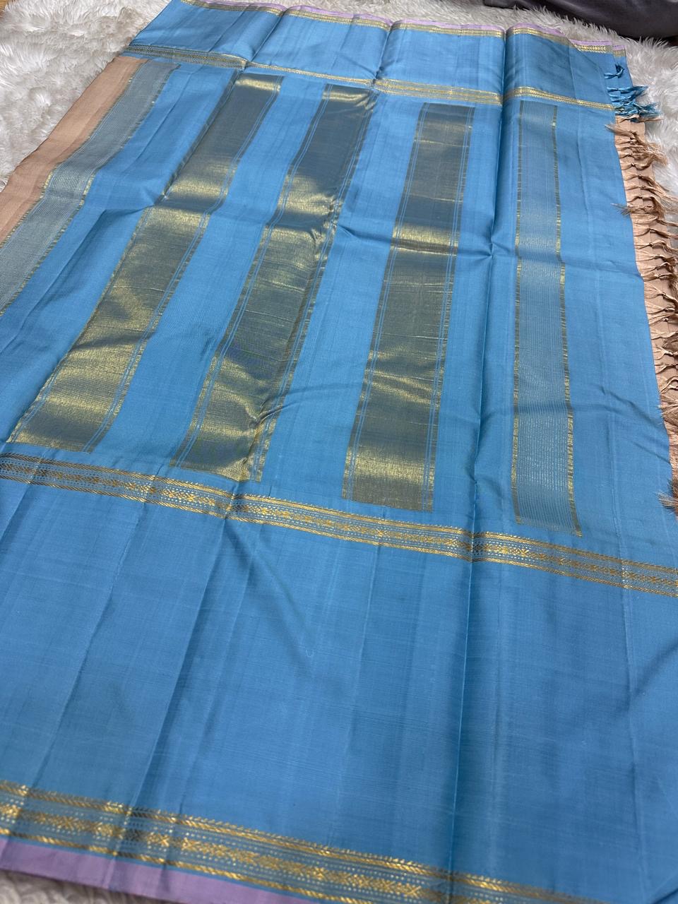 Cerulean blue Korvai border detail with Thazhampoo Reku gold zari lines on handwoven taupe KanchiPattu saree