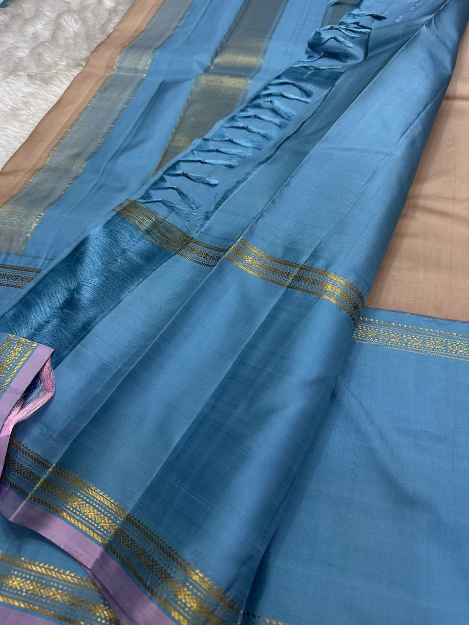 Folded view of taupe and cerulean blue handwoven pure silk KanchiPattu saree with Korvai Thazhampoo Reku border