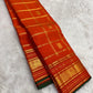 Handwoven Kanchipuram Zari Kattam saree in burnt orange with green selvedge, Kamalam Butta, and Mayil Butta gold zari border, full folded view