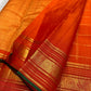 Close-up of burnt orange silk body with fine gold Zari Kattam grid and Kamalam Butta — Kanchipuram saree