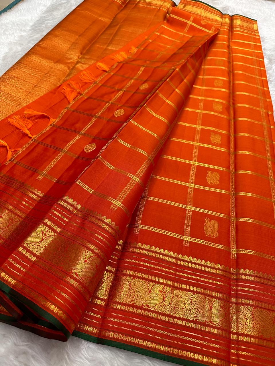 Multi-band Mayil Butta gold zari border with green selvedge on burnt orange Kanchipuram Zari Kattam saree