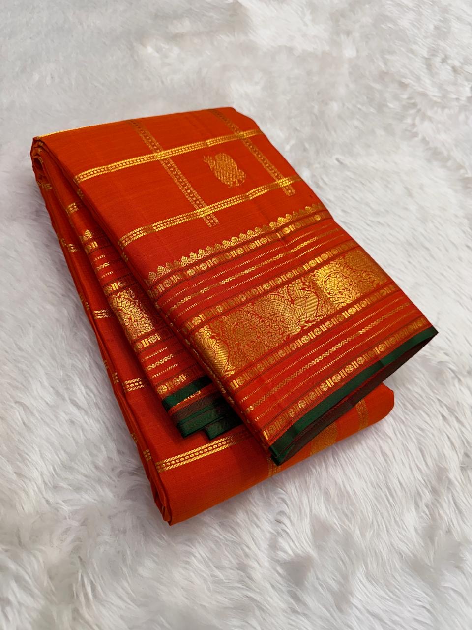 Gold zari Mayil Butta peacock pallu on burnt orange ground — Kanchipuram Zari Kattam saree