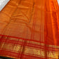 Full folded view of burnt orange Kanchipuram Zari Kattam saree showing body grid and green selvedge border