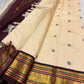 Folded view of the handwoven ivory and arakku red Kanchipuram pure silk saree showing Yaanai Butta body and Varisaipet border