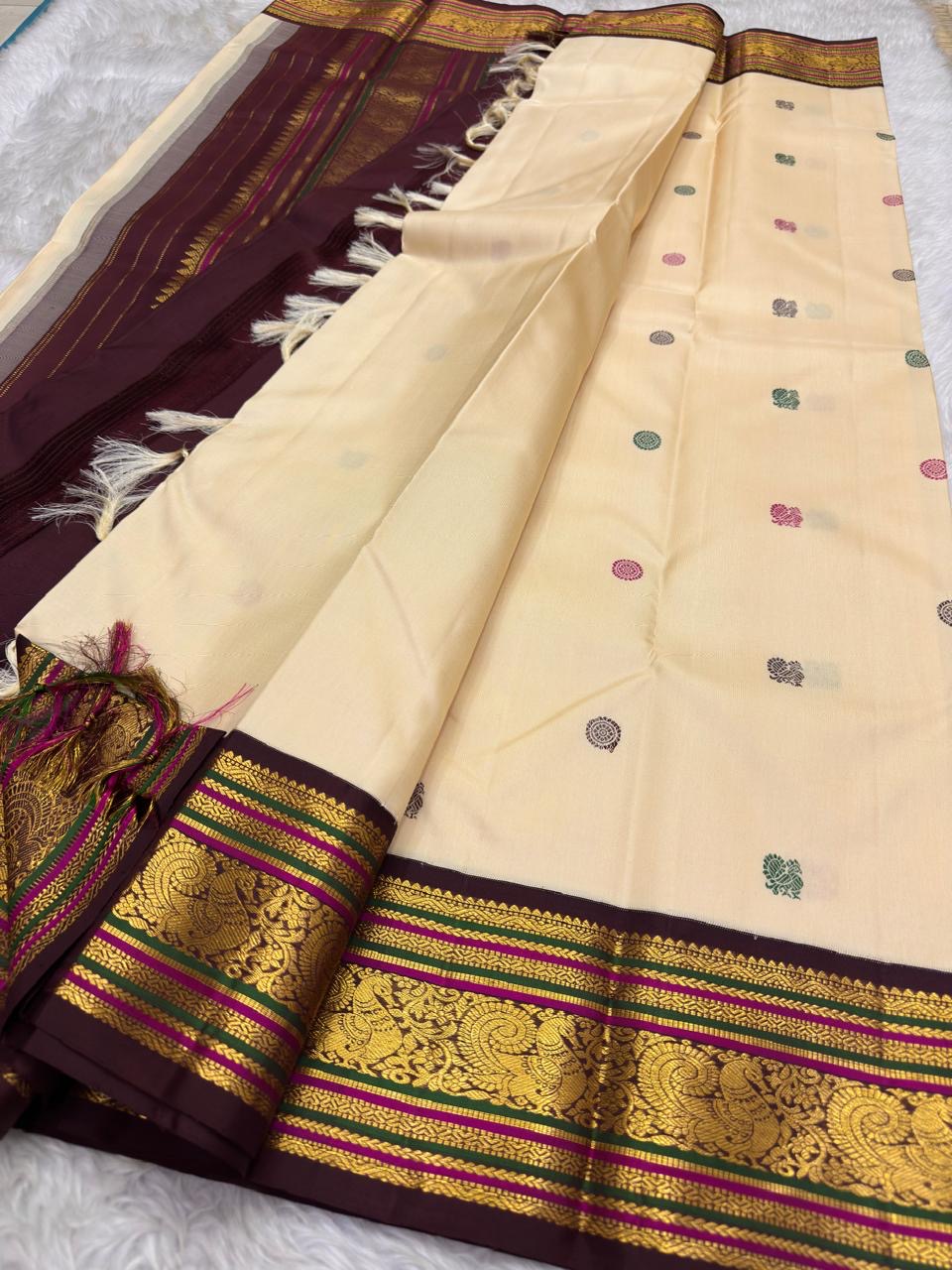 Folded view of the handwoven ivory and arakku red Kanchipuram pure silk saree showing Yaanai Butta body and Varisaipet border