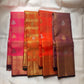 Full folded view of Kanjipuram Veldhari saree showing shot copper-plum body and deep green gold border contrast