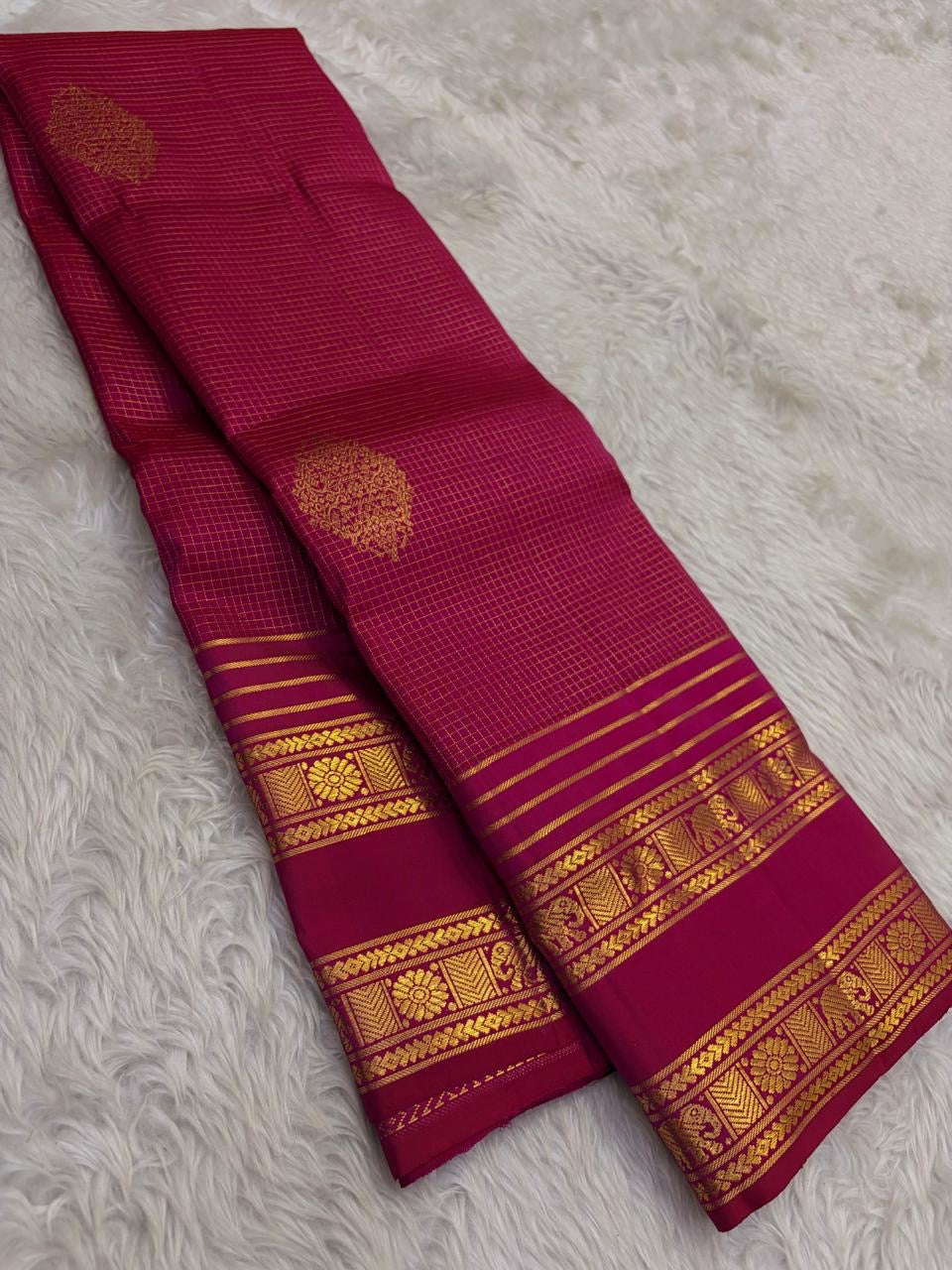 Pallu detail of arakku red pure silk Kanchipuram saree showing antique gold zari Yaanai elephant and Kamalam lotus motifs in Varisaipet border