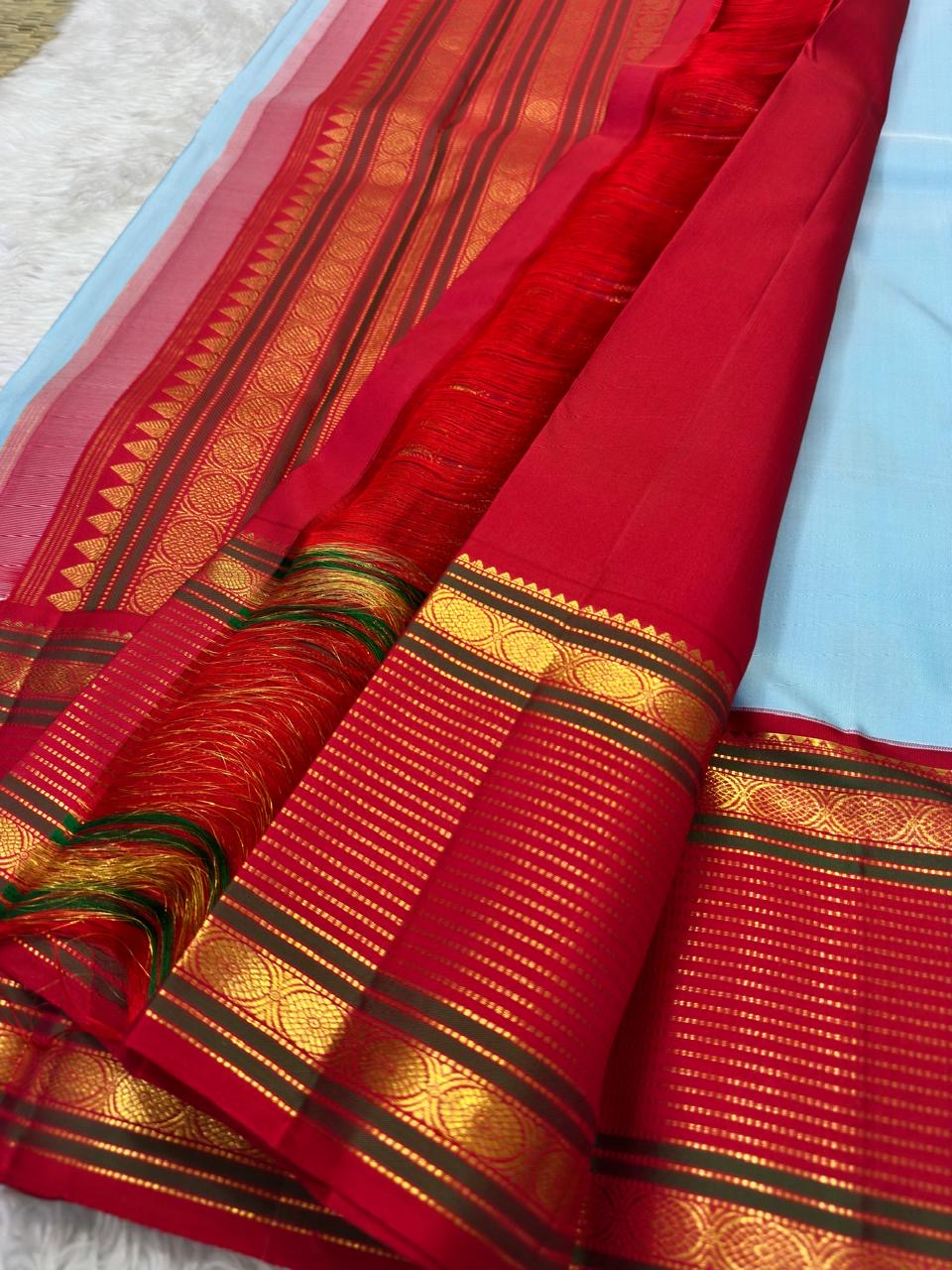 Pallu of the Kanjeevaram Korvai saree showing the Ganga Jamuna contrast — violet-purple and scarlet red with gold horizontal bands