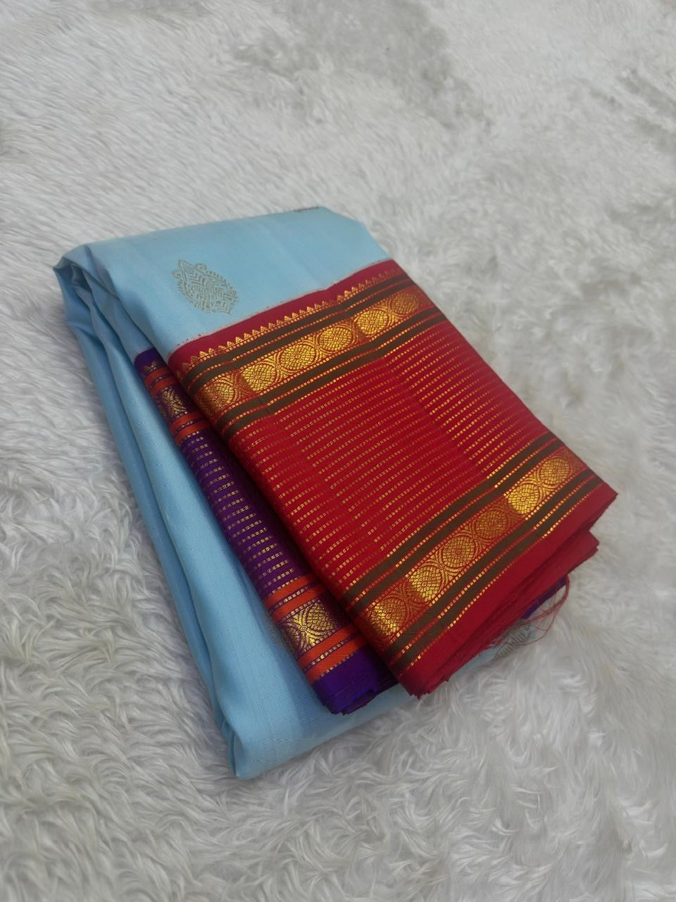 Folded view of the handwoven sky blue Kanjeevaram silk saree showing Maanga Butta body and Ganga Jamuna border