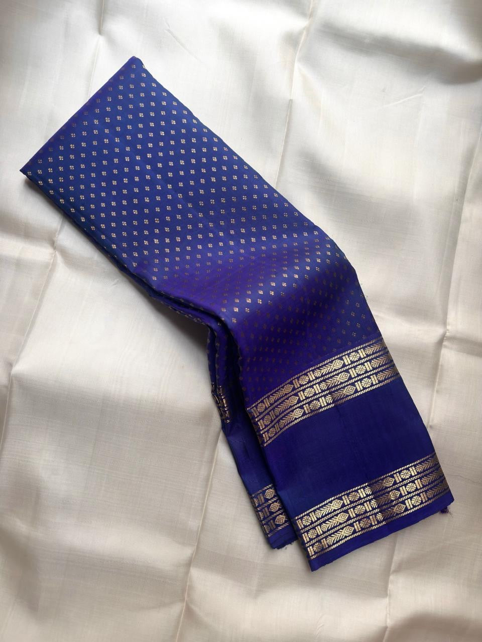 Handwoven Kanjeevaram Rettapet saree in royal blue with scattered Floral Butta and antique gold geometric zari border, full folded view
