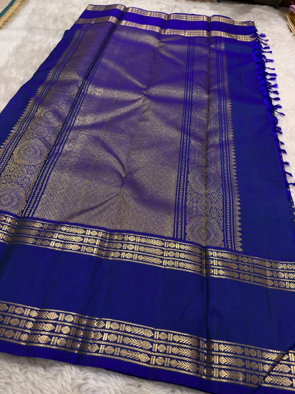Close-up of royal blue silk body with diagonal repeating Floral Butta in antique gold zari — Kanjeevaram Rettapet