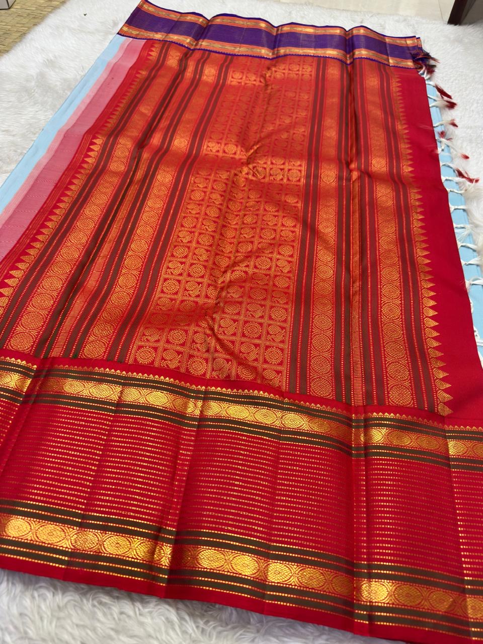 Ganga Jamuna border of the Kanjeevaram Korvai saree — violet-purple side with horizontal gold zari bands and circular medallion motifs