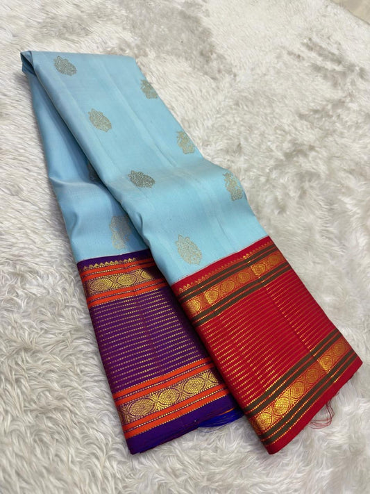 Close view of the sky blue silk body showing Maanga Butta mango motifs scattered in gold zari across the full length