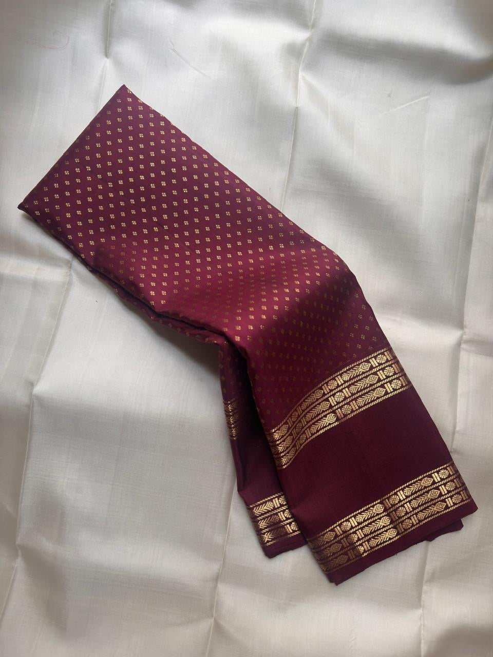 Handwoven Kanjipuram Rettapet saree in deep burgundy with Floral Butta and antique gold geometric zari border, full folded view