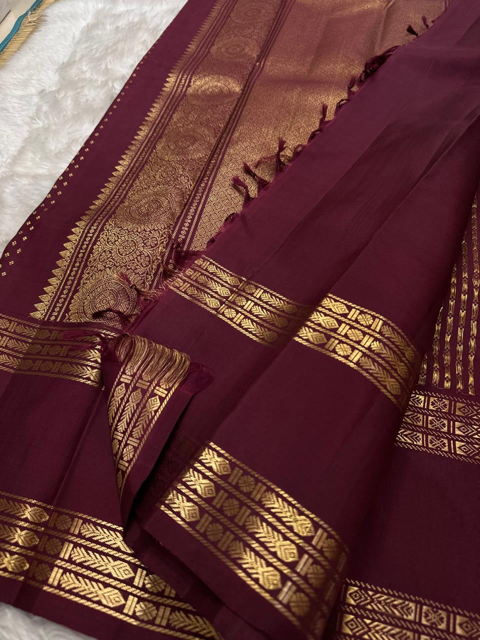 Full folded view of burgundy Kanjipuram Rettapet saree showing Floral Butta body and self-colour border
