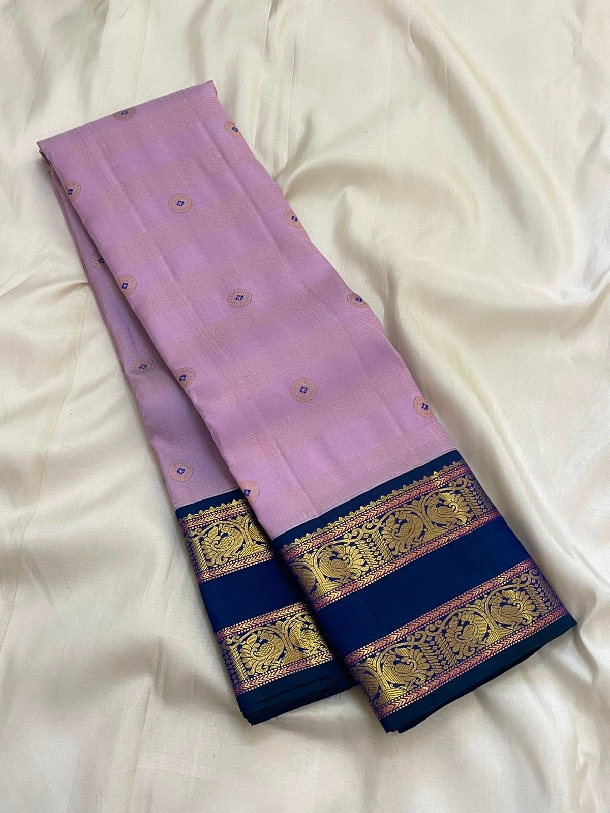Full folded view of lavender Kanjipuram Butta saree showing Meenakari body and deep navy border contrast