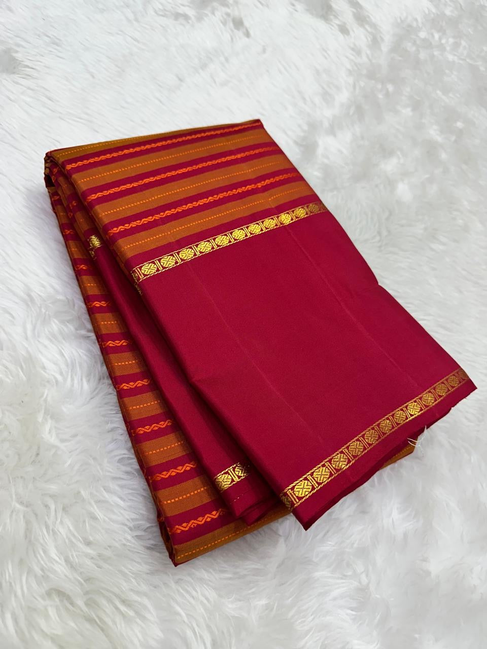 Fine chain-stitch zari detailing on Vazhaipu Veldhari horizontal stripe body of handwoven orange and arakku red Kanjipuram saree