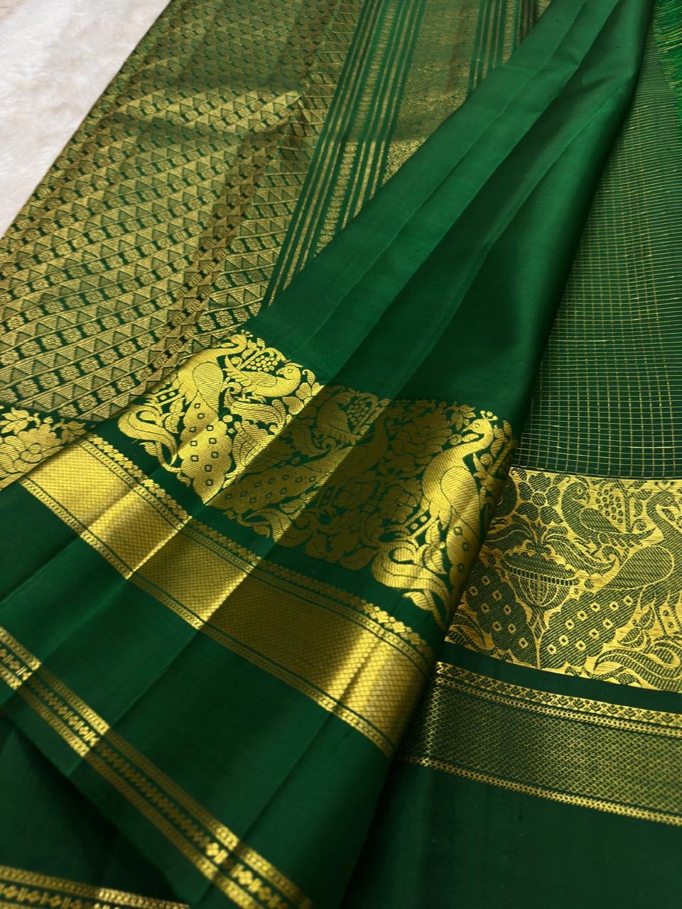 Handwoven Kanjivaram Zari Kattam saree in self-colour forest green with Floral Butta and grand Mayil Butta peacock gold pallu, full folded view