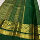 Full folded view of forest green Kanjivaram Zari Kattam saree showing grid body and grand peacock pallu