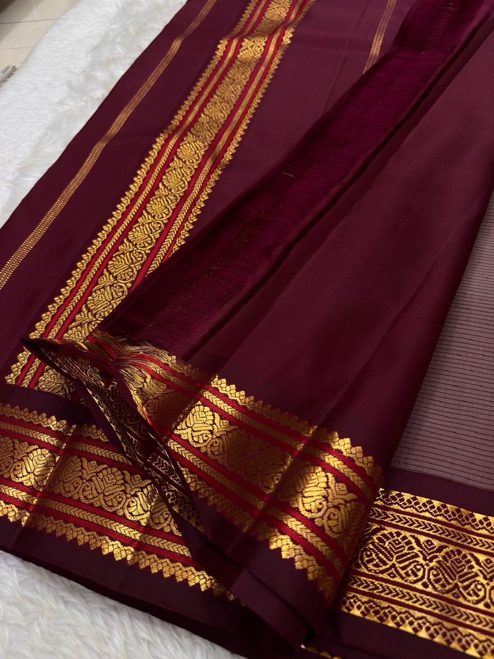 Folded view of the handwoven steel grey and maroon Kanjivaram pure silk saree showing woven stripe body and Varisaipet Korvai border