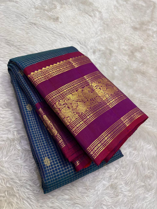 Close-up of deep teal Zari Kattam silk body showing fine intersecting gold zari grid and scattered gold buttas on pure silk Kanjivaram saree