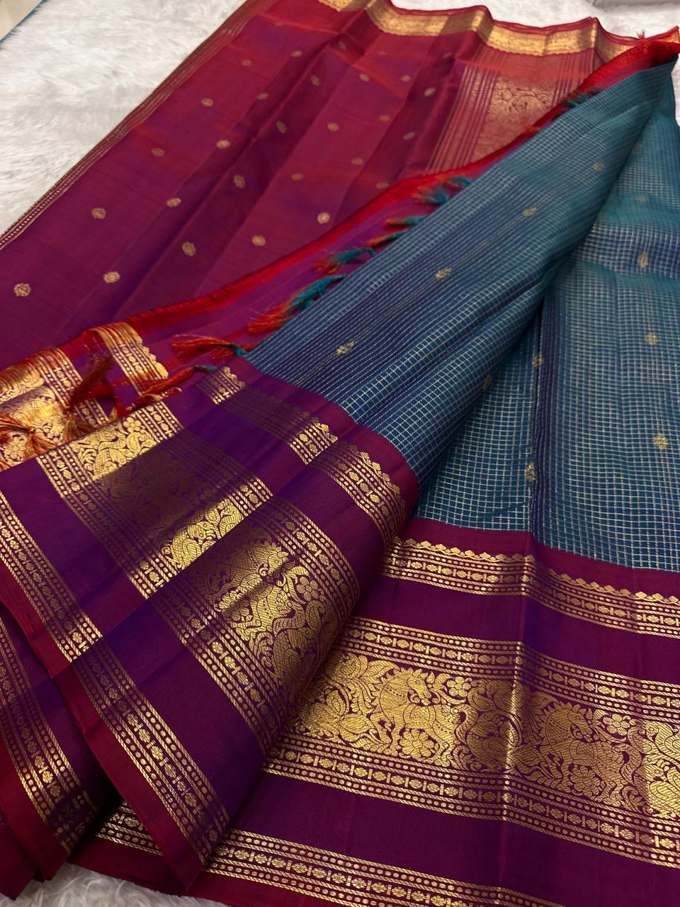 Pallu detail of teal and arakku red pure silk Kanjivaram saree showing antique gold zari elephant procession in arakku red Rettapet border