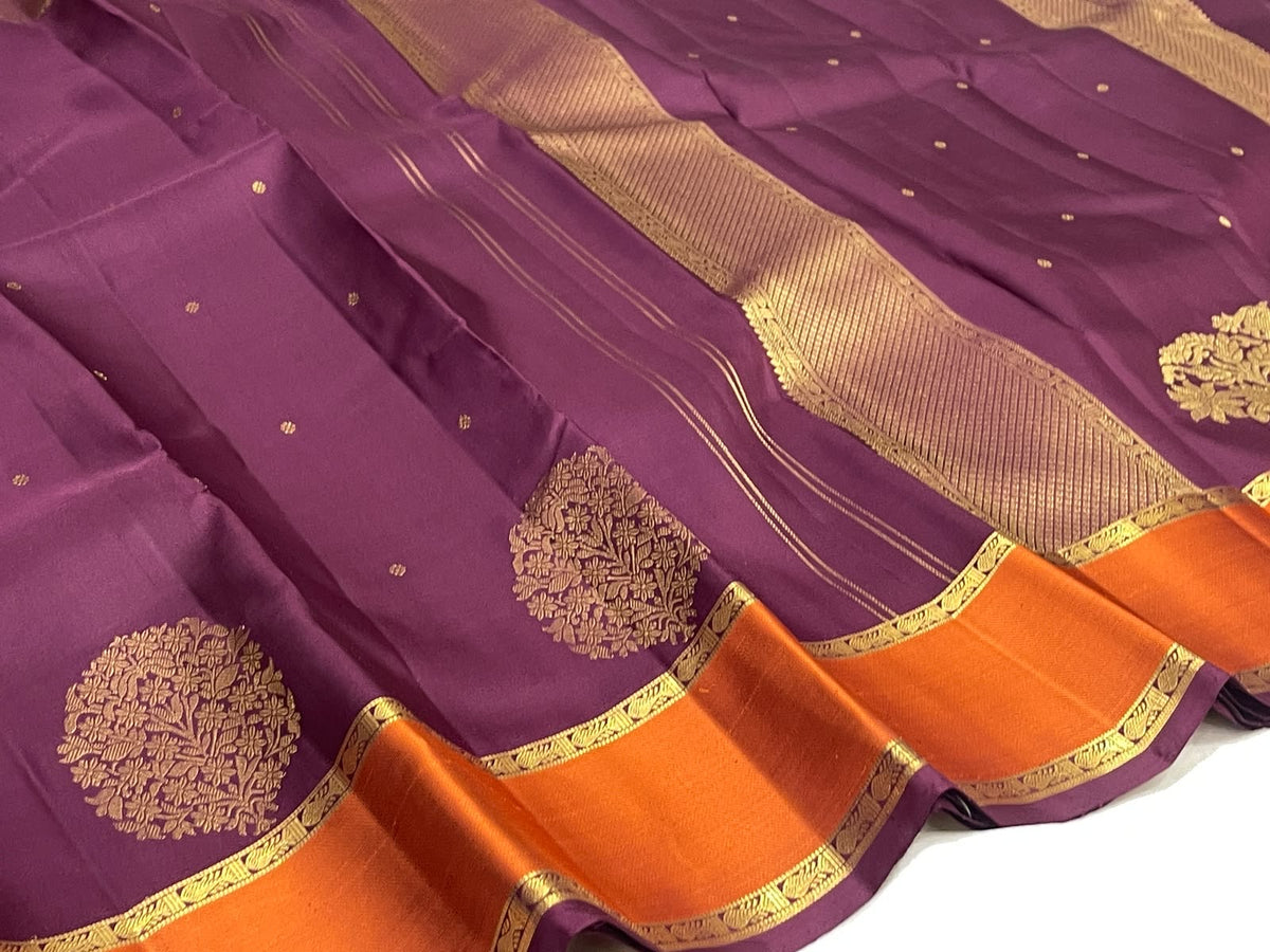 Burnished orange border on a muted aubergine Kancheepuram saree