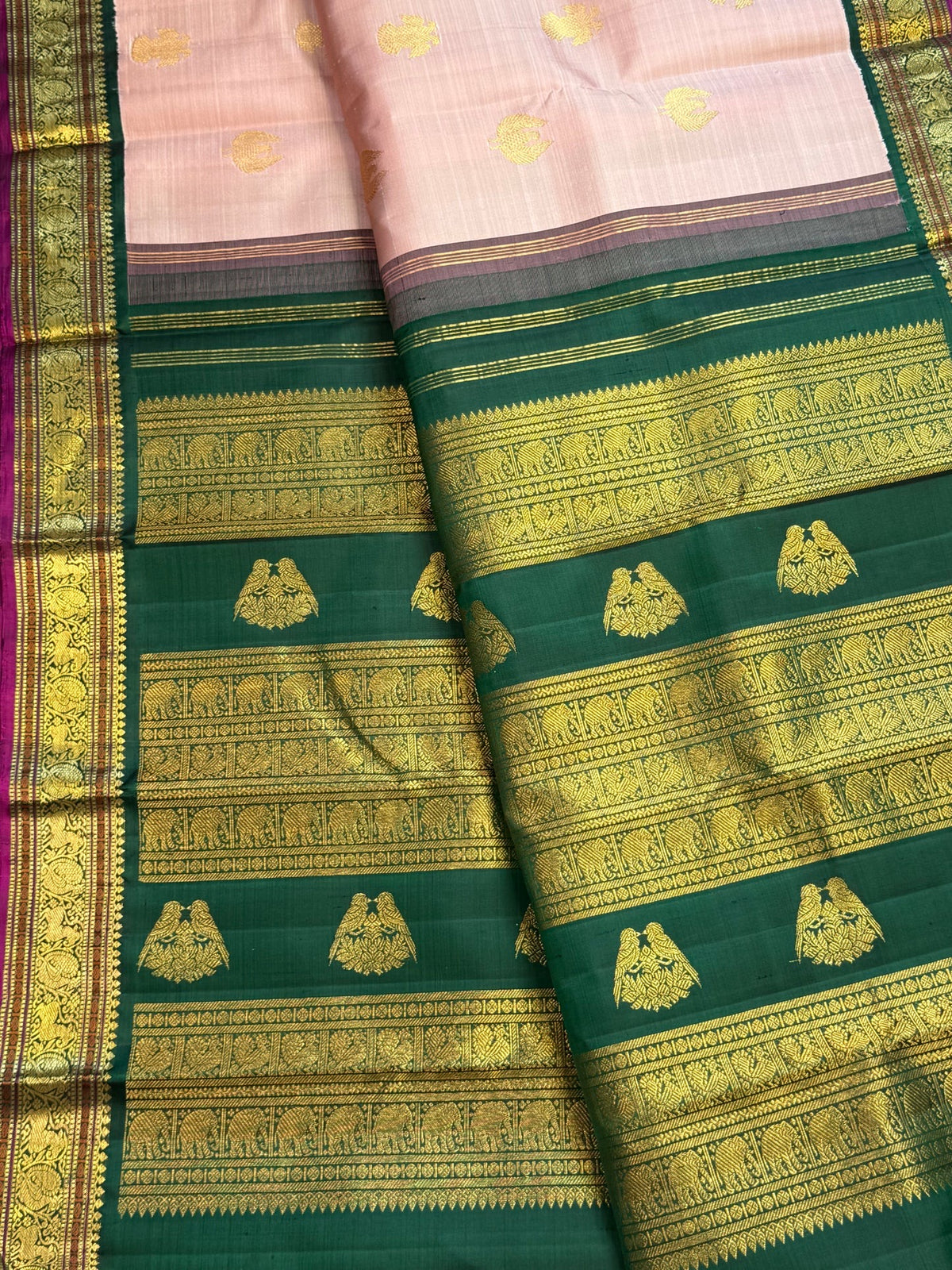 Detailed border view of petal pink Kanchipuram saree with traditional gold zari motifs