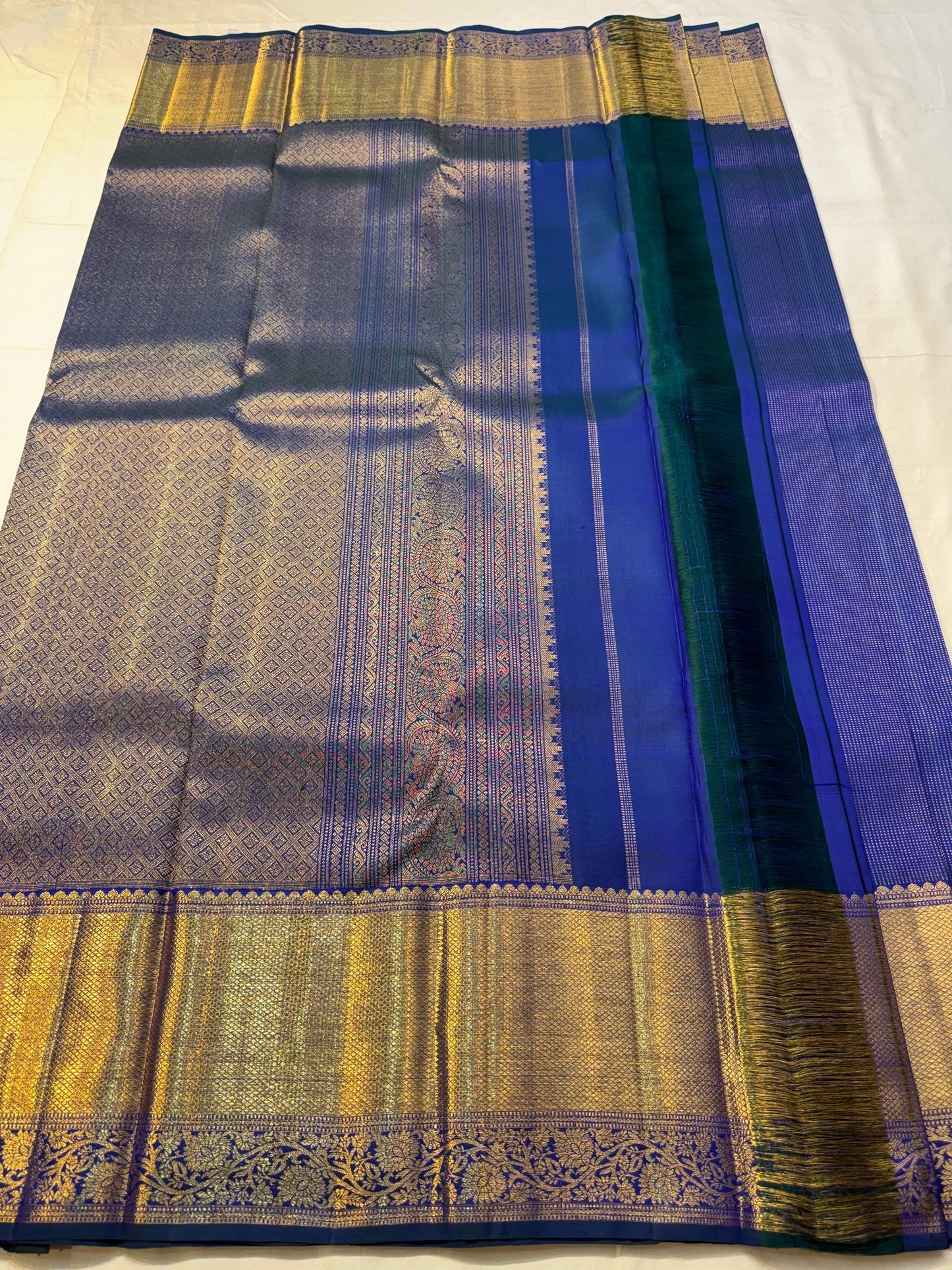 Wide gold zari border with scalloped upper edge on navy Kanchipuram silk saree