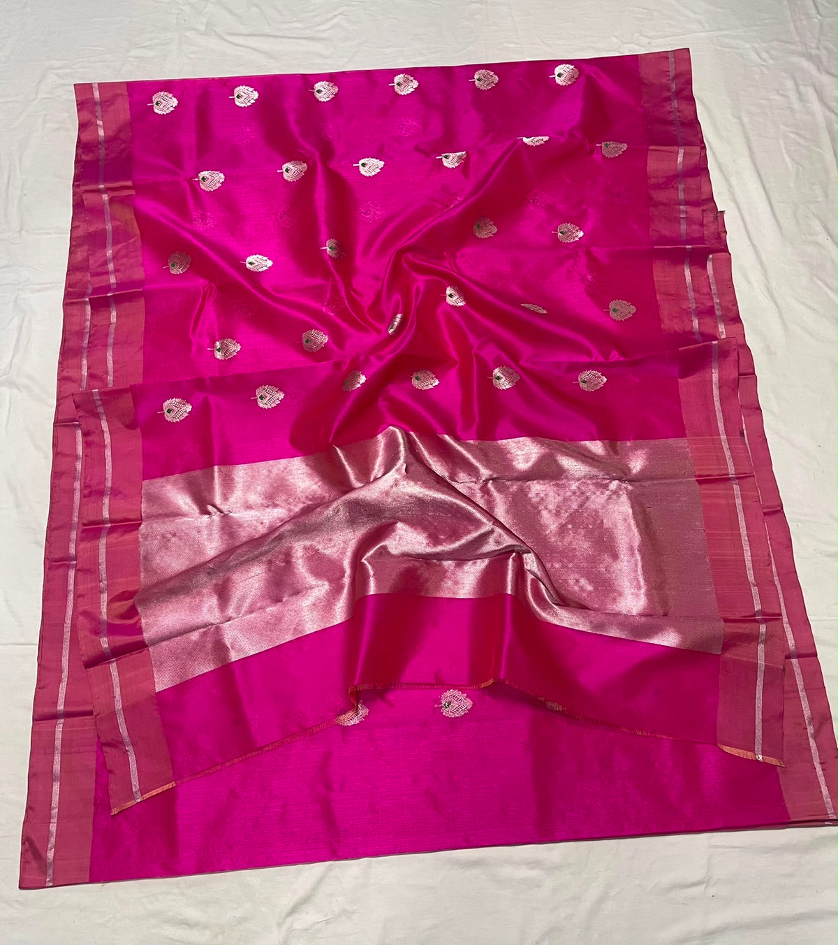 Folded Rani Pink Pattu Silk Chanderi saree with silver zari paisley buttas, green accents and tonal rose border