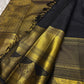 Pure Kanchipuram silk saree drape view with black body, vertical gold zari stripes, and wide gold zari border near tassels