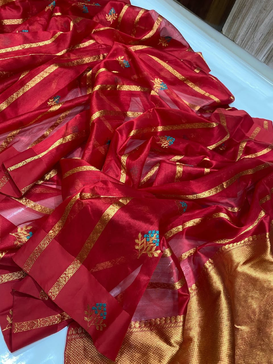 Full Raspberry Red Pattu Silk Chanderi saree with turquoise floral buttas and gold zari stripes