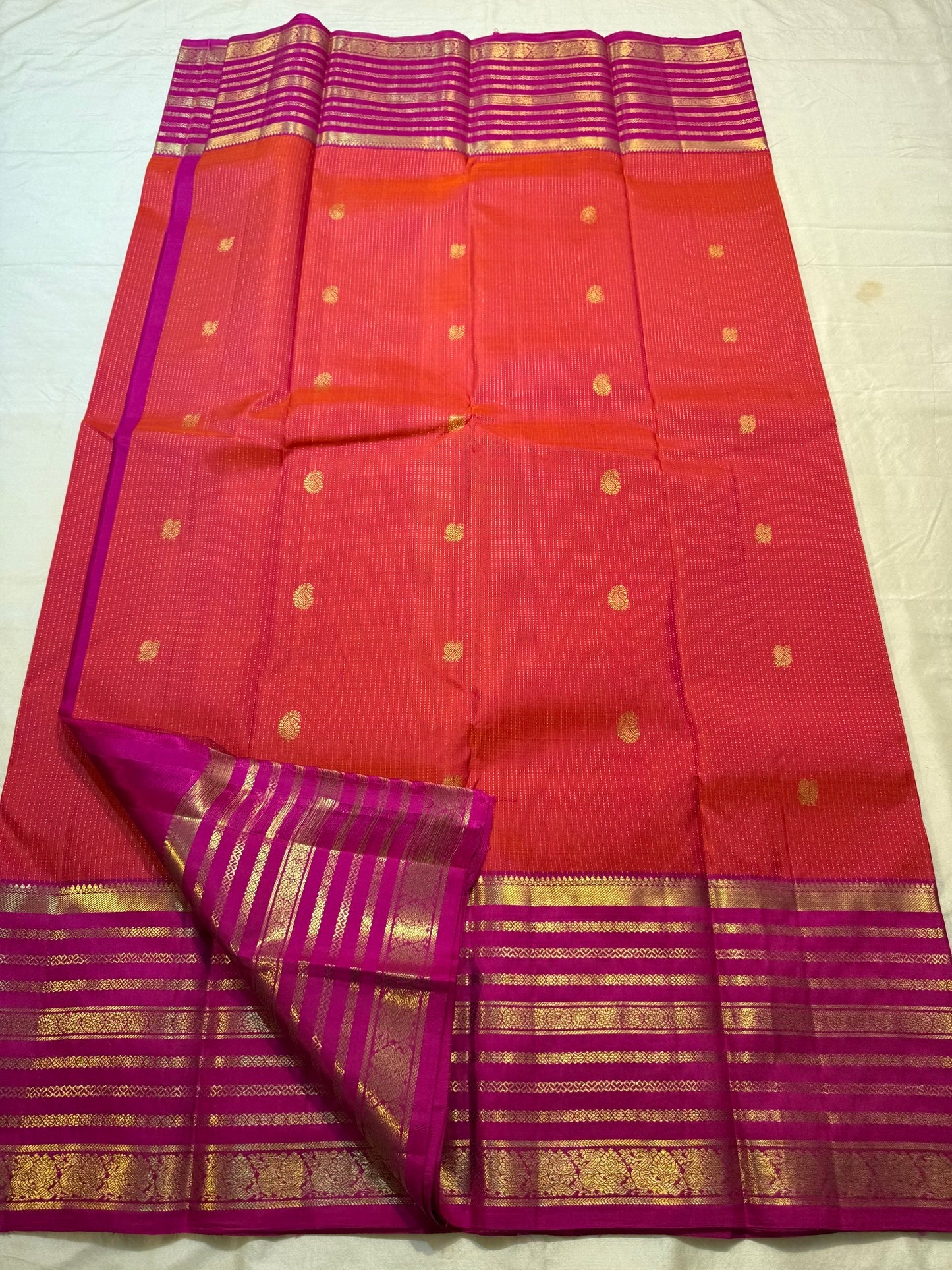 Wide magenta Varisaipet border with layered horizontal gold zari bands on red Kanchipuram silk
