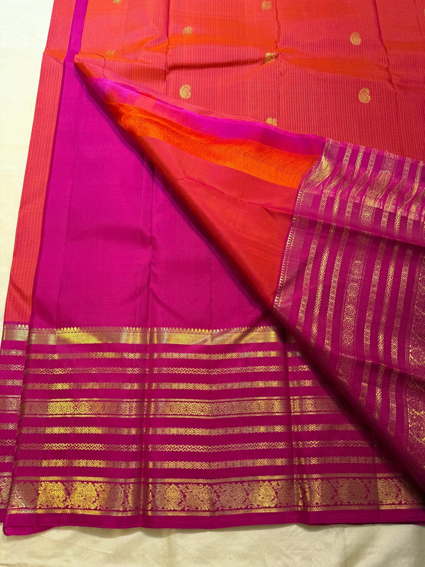 Magenta Kanchipuram pallu with richly layered gold zari band structure — full spread