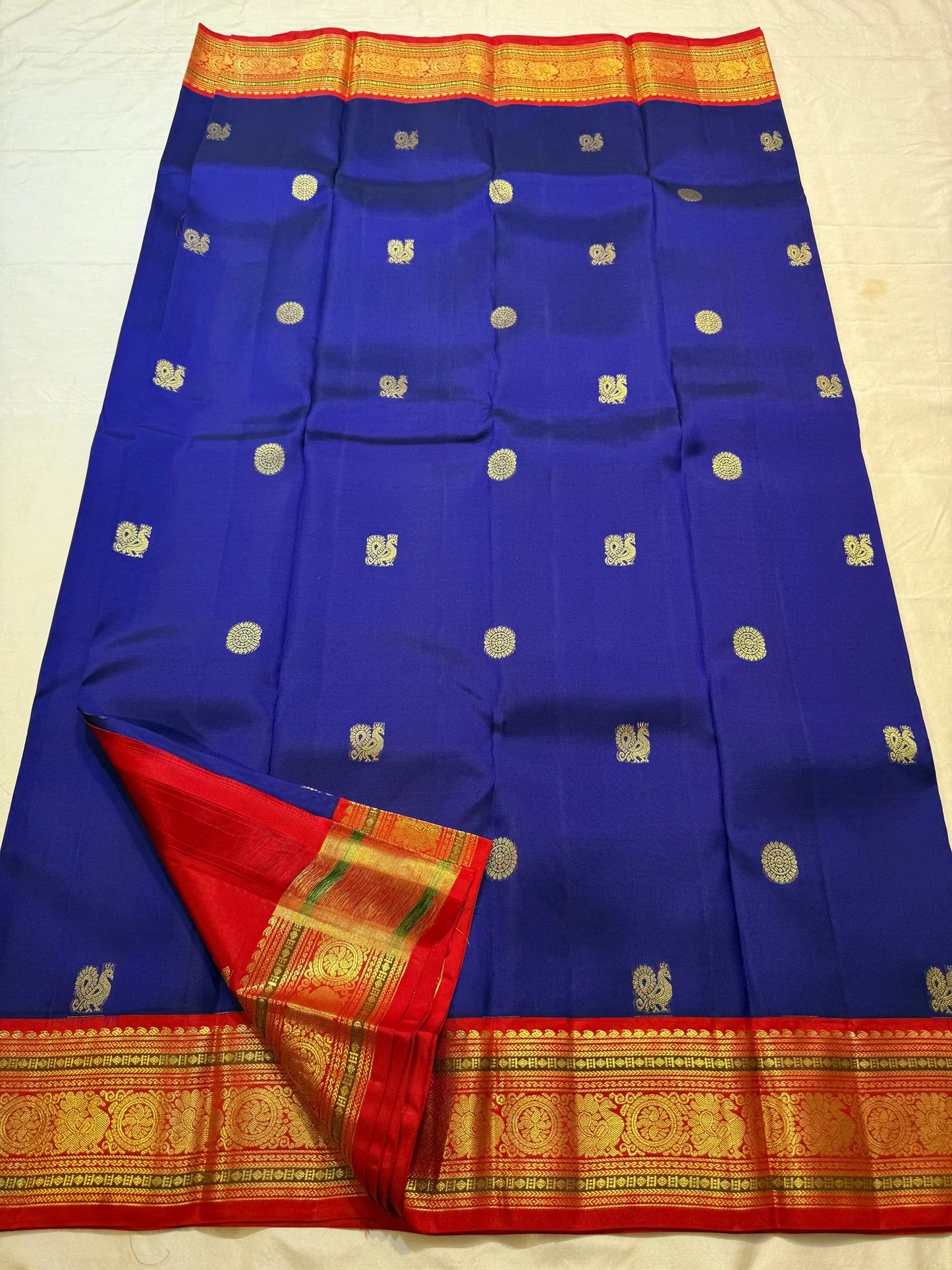 Wide red Varisaipet border with multiple gold zari bands and Kamalam Kili butta motifs on royal blue Kanchipuram silk