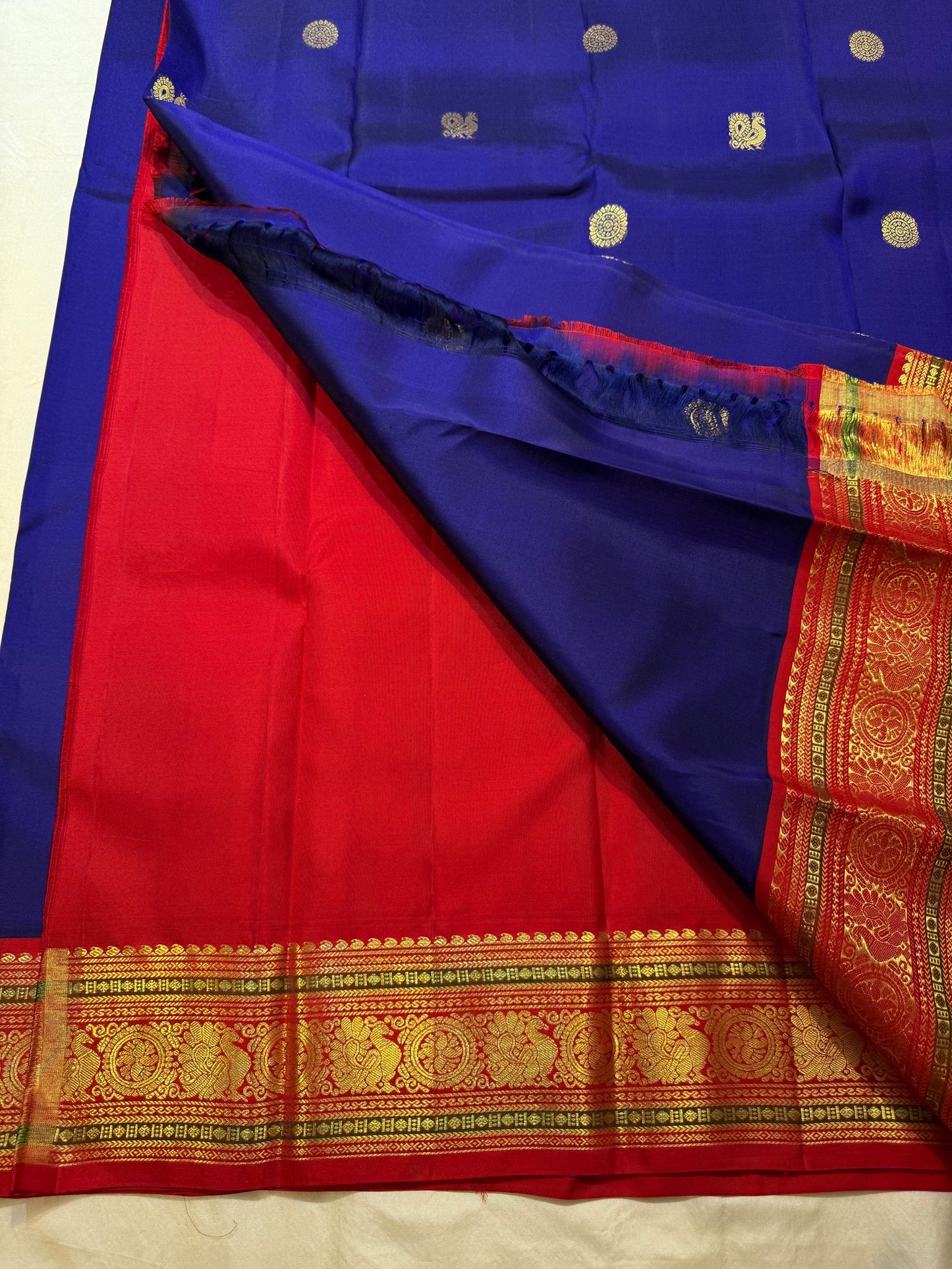 Deep royal blue Kanchipuram saree body with scattered Kamalam and Kili butta in gold zari — close-up