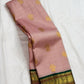 Folded view of petal pink Kanchipuram silk saree with contrast emerald green zari border and magenta edge