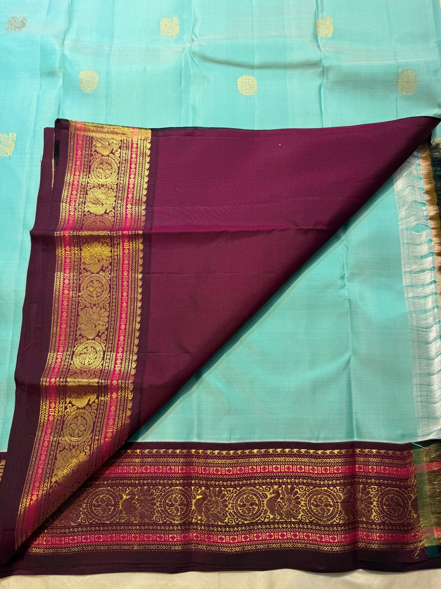 Wide deep maroon Varisaipet border with layered gold zari bands and Kamalam Kili motifs on sky blue Kanchipuram silk