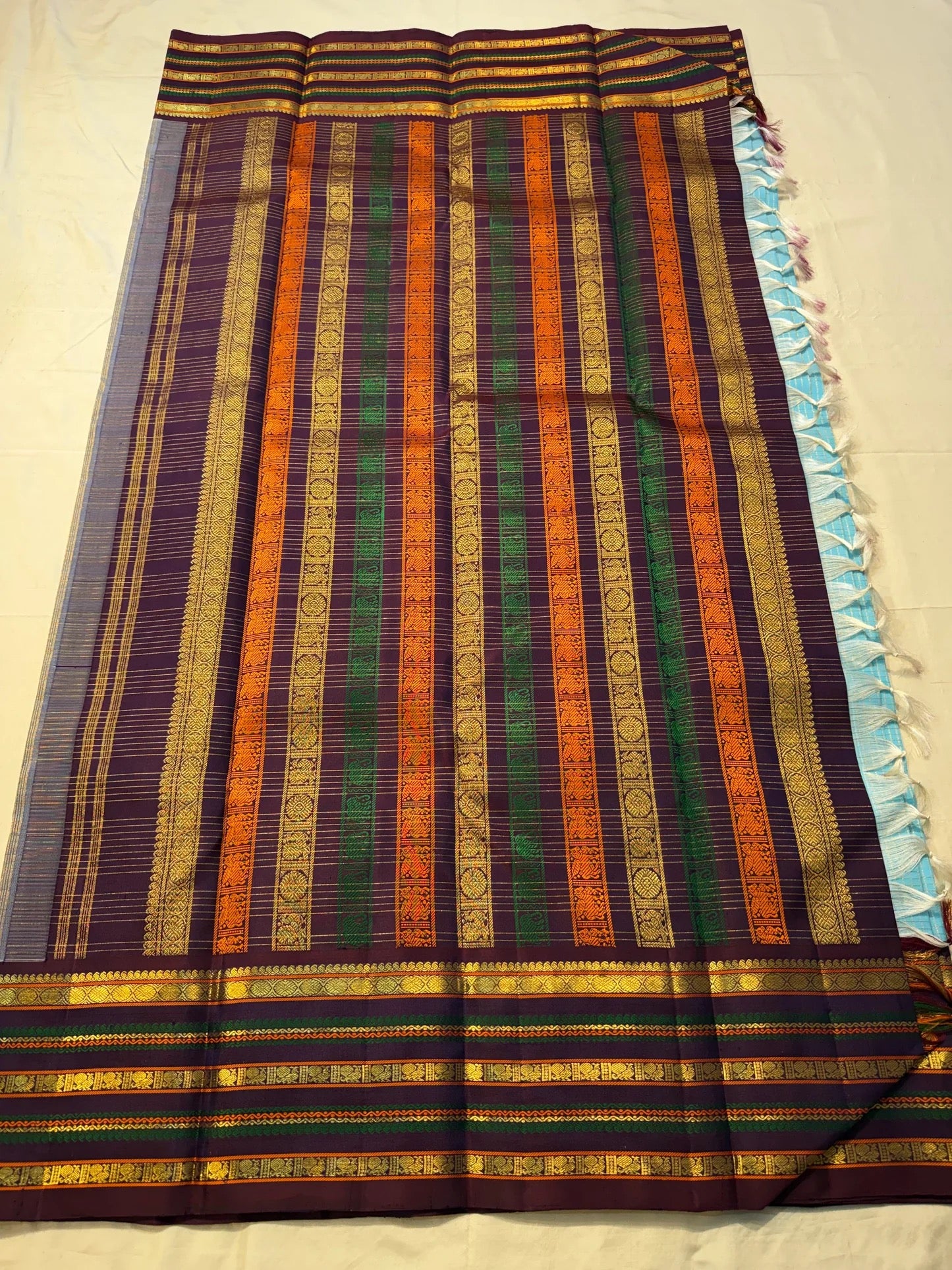 Deep maroon Varisaipet border with layered gold zari bands and green accent stripes
