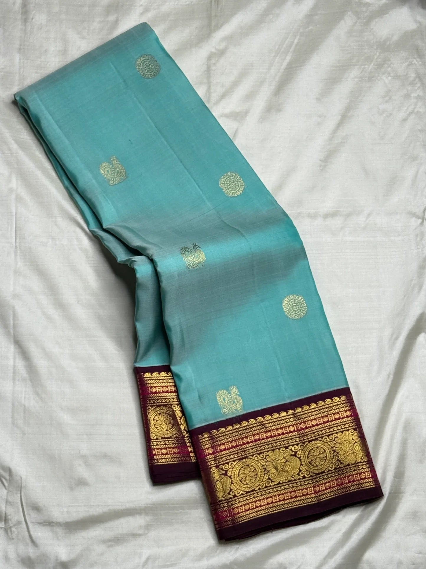 Sky blue and maroon Kanchipuram butta saree folded flat — full length view