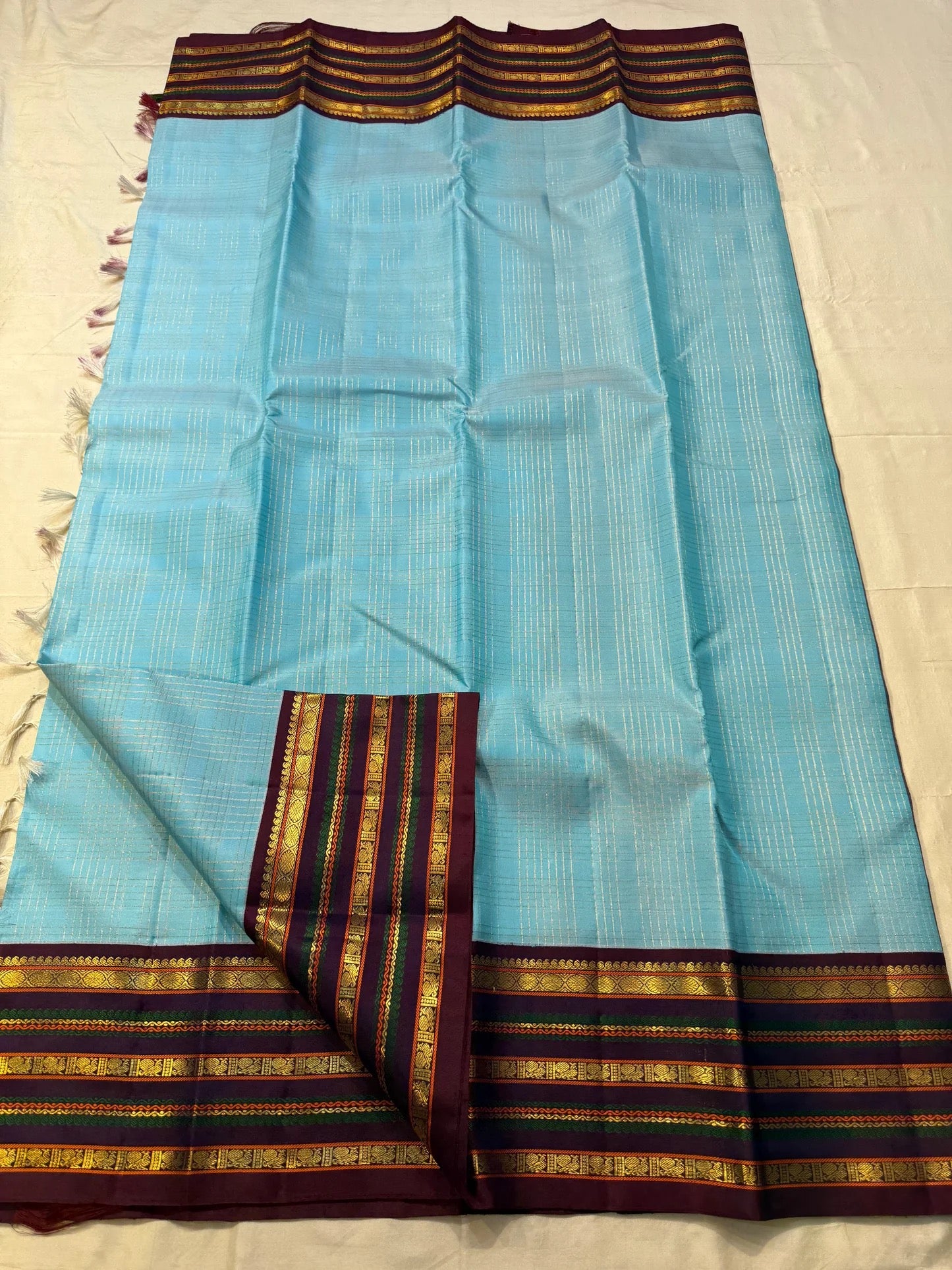 Sky blue and maroon Kanchipuram silk saree folded flat — full length view
