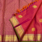 Close view of rani pink vairaoosi silk body with gold buttas and wide zari border alongside purple pallu section