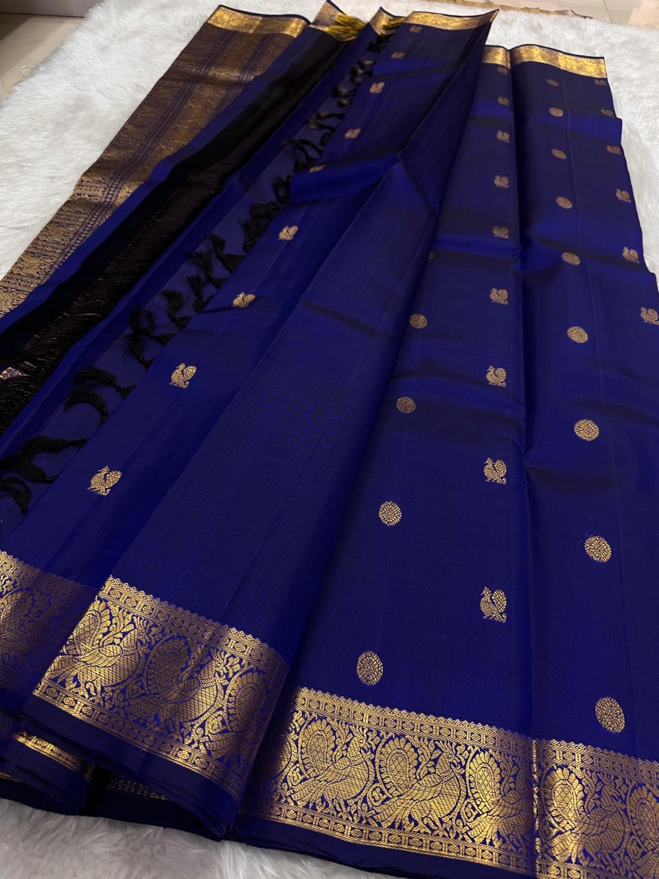 Handwoven Kanjeevaram silk saree featuring traditional gold buttas across a sapphire blue body